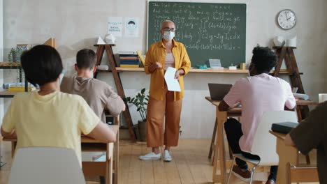 Teacher-in-Mask-Giving-Lesson-to-Students-in-Classroom